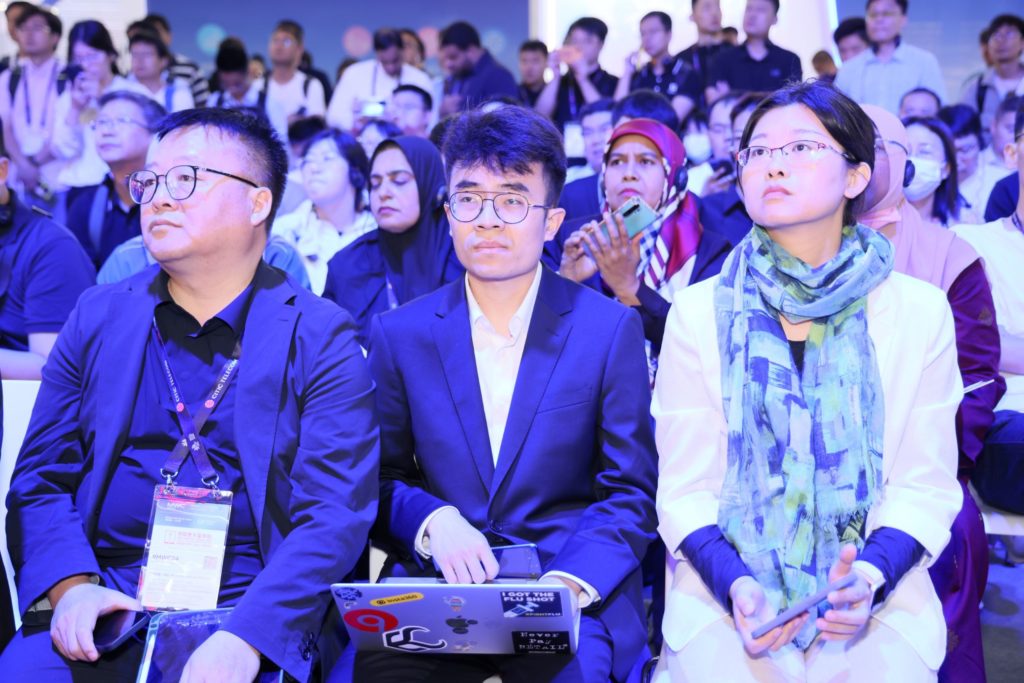 3 people sitting down in the in crowd