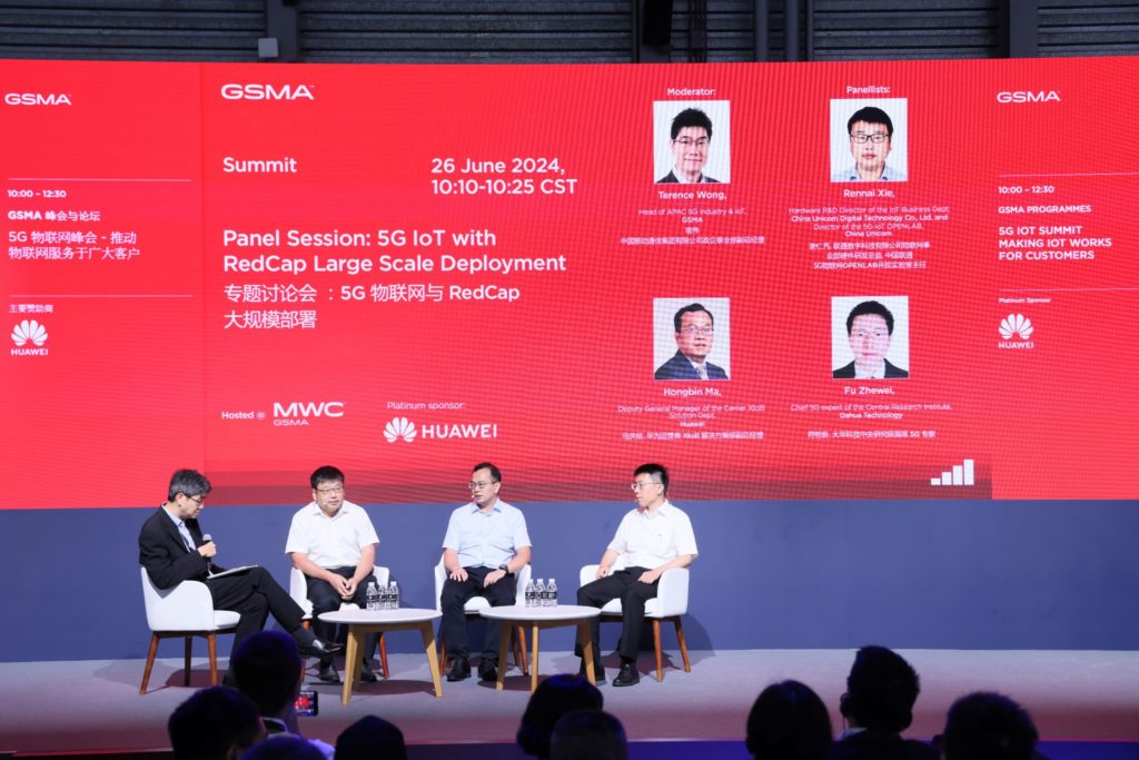 4 men sitting on stage talking to each other