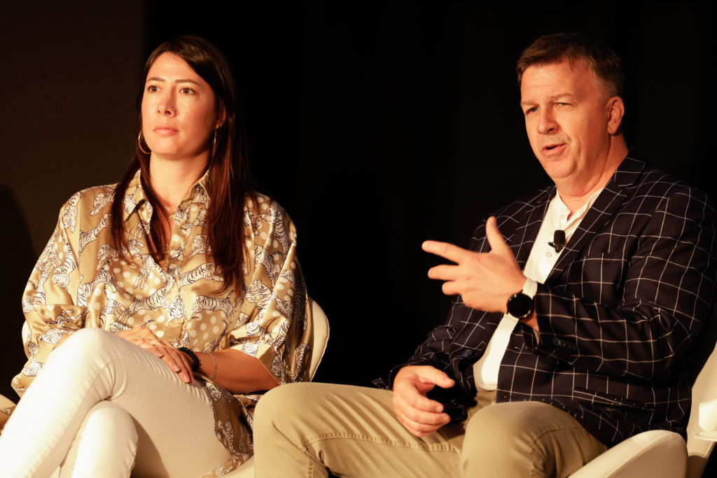 A woman and man on stage. The man speaking