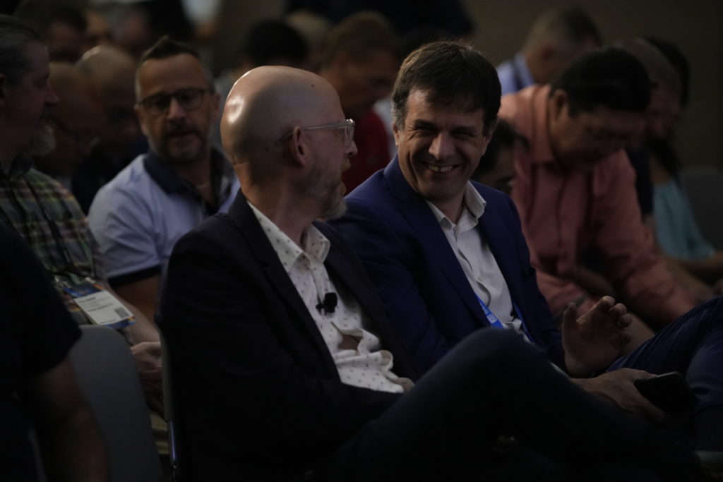 Two men sitting next to each other laughing