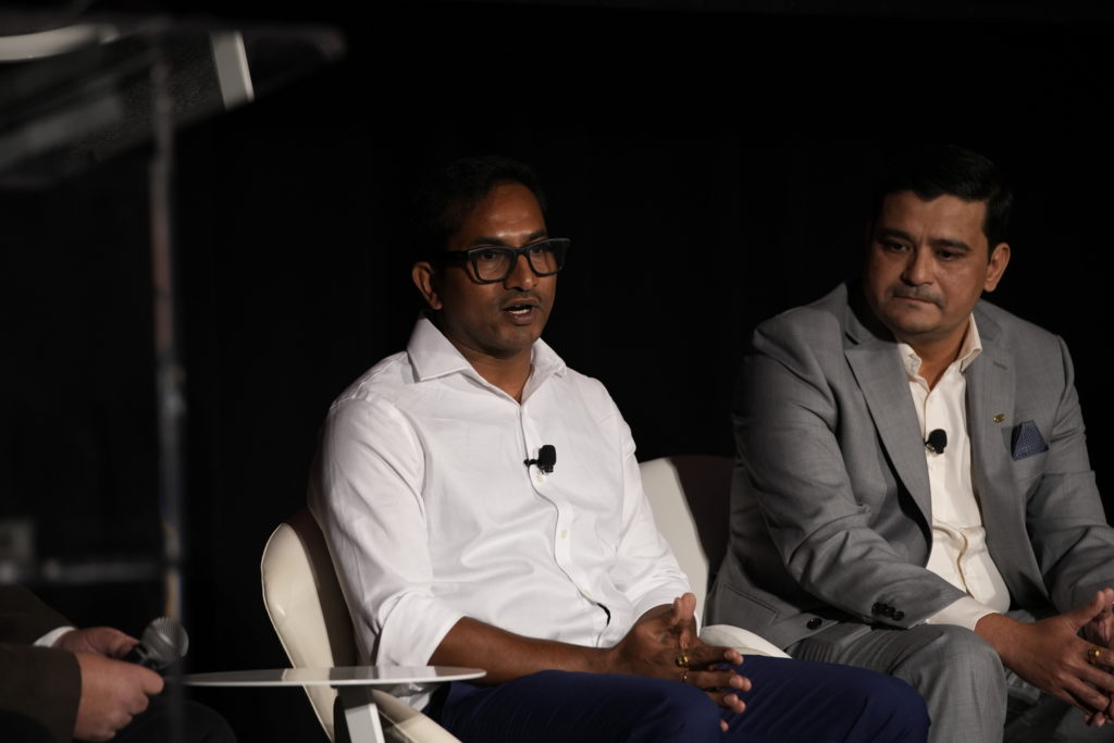 Two men on stage and one speaking