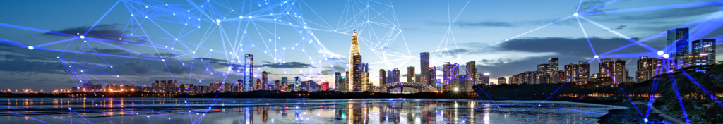 A city skyline at dusk features modern skyscrapers reflected in calm water. Blue digital lines and nodes are superimposed, suggesting technology, connectivity, or a smart city concept, with a glowing, futuristic atmosphere under a partly cloudy sky.