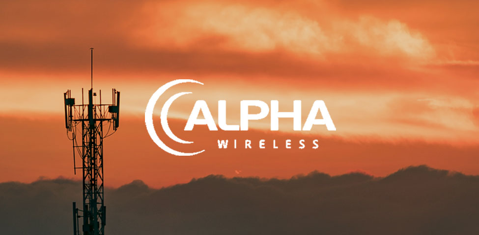 A telecommunications tower silhouetted against an orange sky at sunset, with the logo "Alpha Wireless" overlayed in white. The sky features scattered clouds, and the overall scene conveys a sense of connectivity in a tranquil setting.