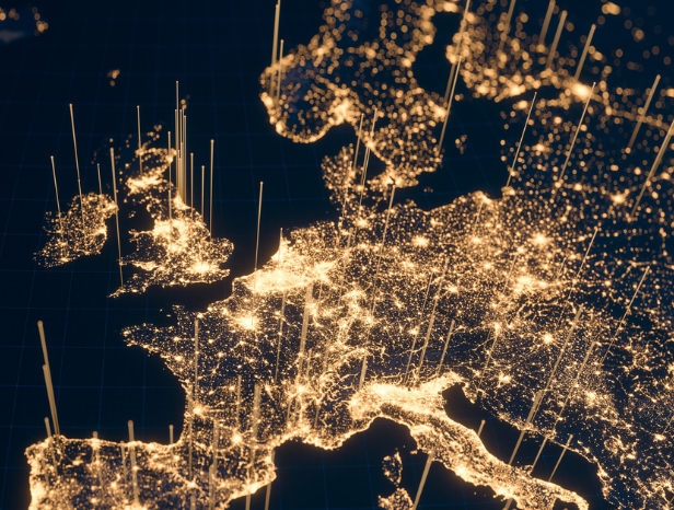 A detailed map of Europe at night shows illuminated cities and regions. Bright lights densely cover Western Europe, highlighting urban areas. Vertical lines extend from the lights, suggesting data visualization or connectivity. Dark seas contrast with the glowing landmasses.