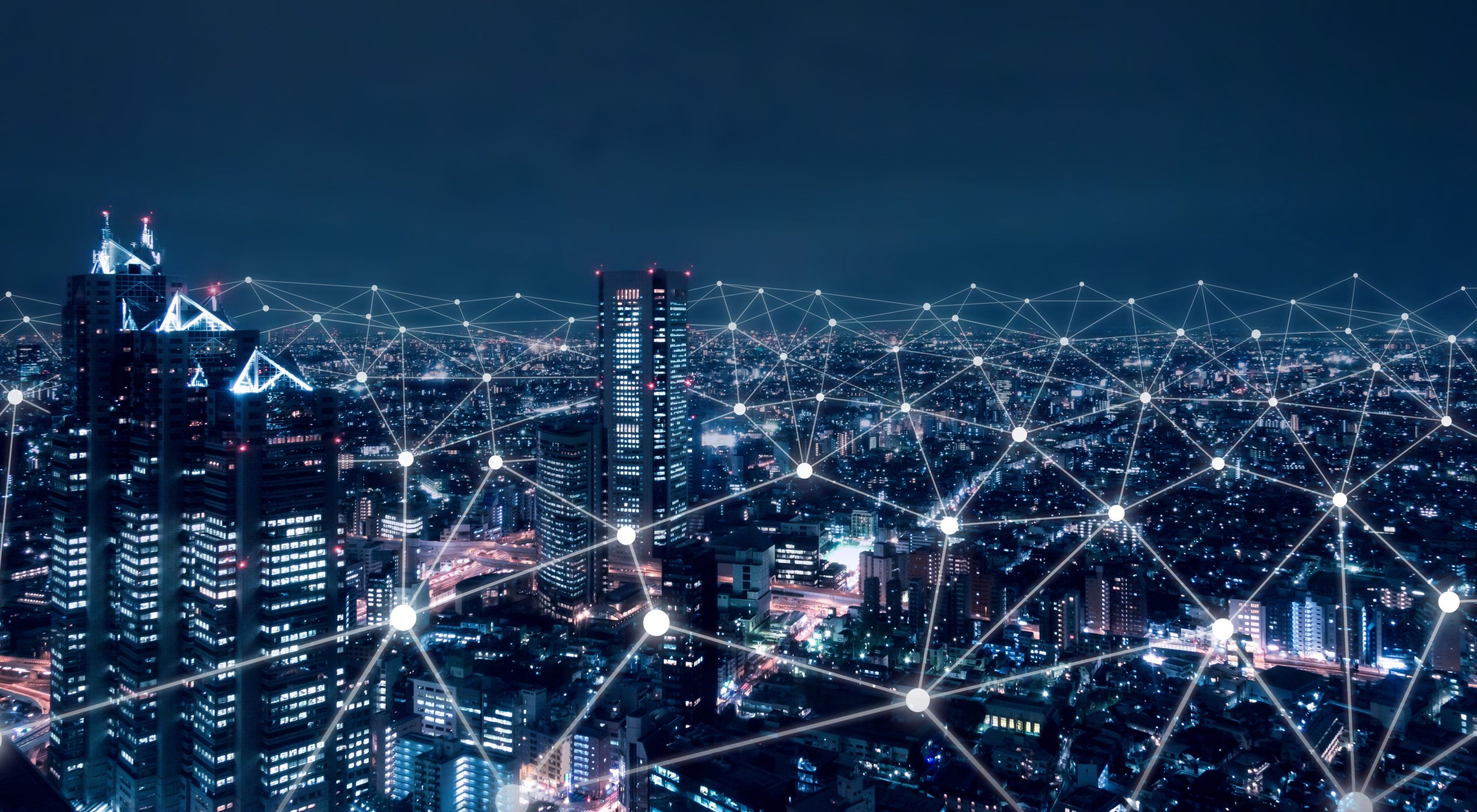 A city skyline at night with glowing network lines and nodes superimposed, symbolising digital connectivity.