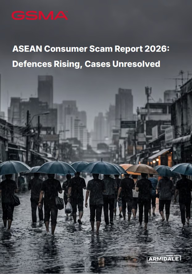 A crowd of people holding umbrellas walks through a rain-soaked city street with tall, blurry grey buildings in the background. The sky is overcast. Text at the top reads, “ASEAN Consumer Scam Report 2026: Defences Rising, Cases Unresolved,” highlighting ongoing efforts in scam prevention.