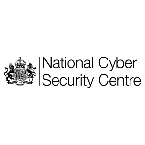 The logo shows a black UK royal coat of arms on the left and the words “National Cyber Security Centre” in black text on the right, all on a light grey background, reflecting the organisation’s commitment to combating threats such as phishing, vishing and smishing.