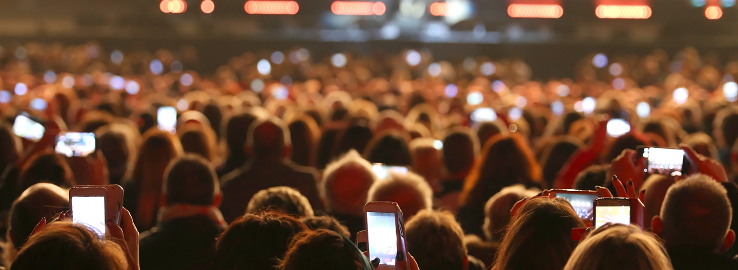 A crowd of people holding cell phones at a concert.