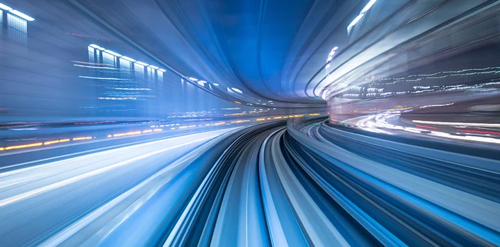 A blurry image of a train traveling through a city.