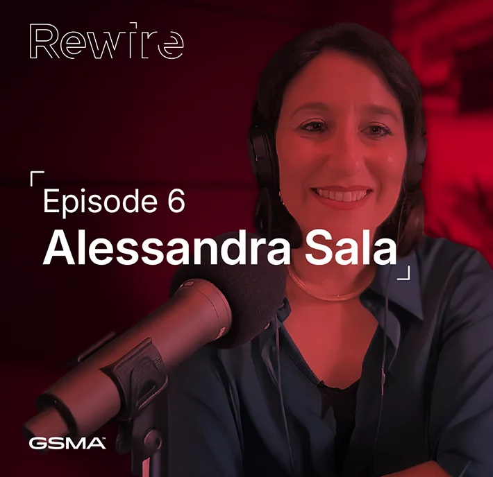 A woman with brown hair wearing headphones and a blue shirt smiles while sitting at a microphone. The background is red. Text reads: "Rewire Episode 6 Alessandra Sala." GSMA logo appears in the lower left corner.