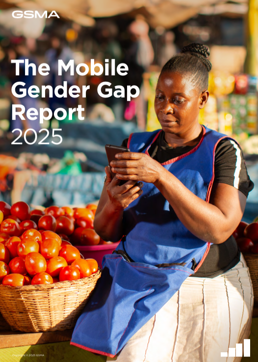 A woman wearing a blue apron stands beside baskets filled with tomatoes in an outdoor market, using her mobile phone. The sun lights the vibrant scene. Text reads: "The Mobile Gender Gap Report 2025." GSMA logo appears in the top left corner.